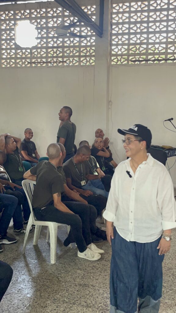 Jóvenes en formación policial, sentados en sillas plásticas, escuchan a la Dra. Maribel Orozco durante la charla.