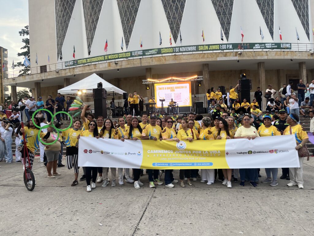 Un grupo numeroso vestido de amarillo sostiene la pancarta de «Caminemos Juntos por la Vida» frente a la catedral, en la Plaza de la Paz.