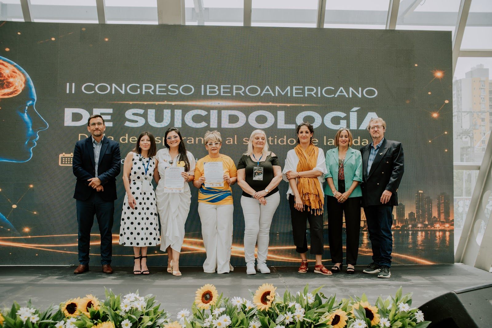 Grupo en el escenario frente al telón del Congreso.