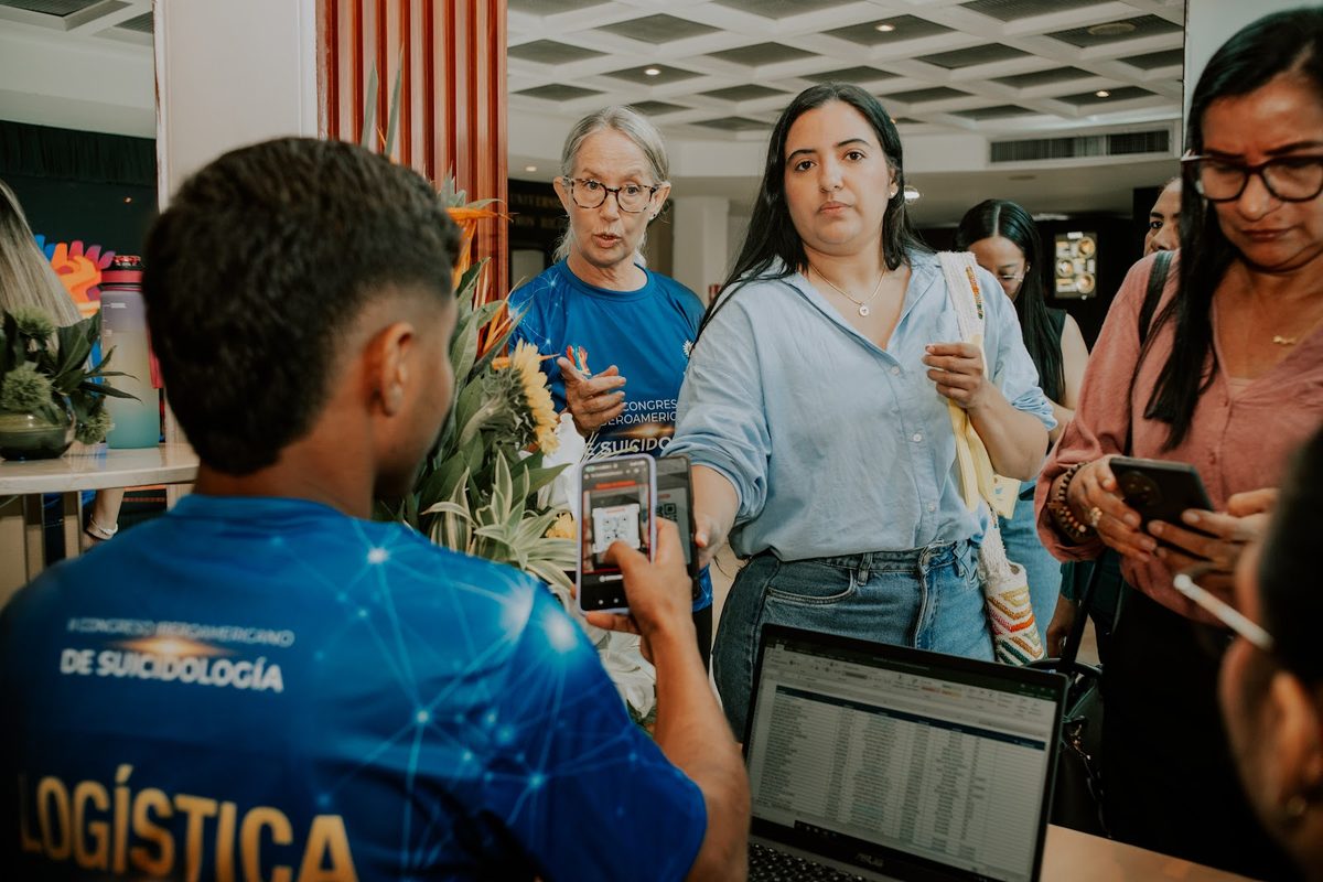 Asistentes recibiendo su material en el punto de acreditación.