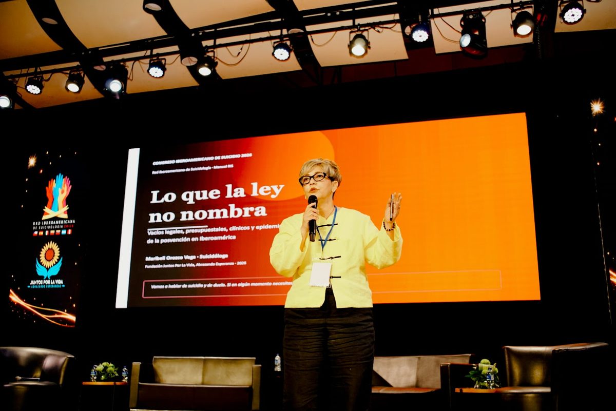 Ponente en el escenario junto a una pantalla con su presentación.